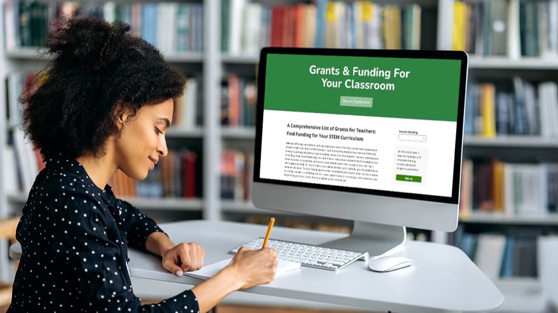 Educator researching grant opportunities on a computer.