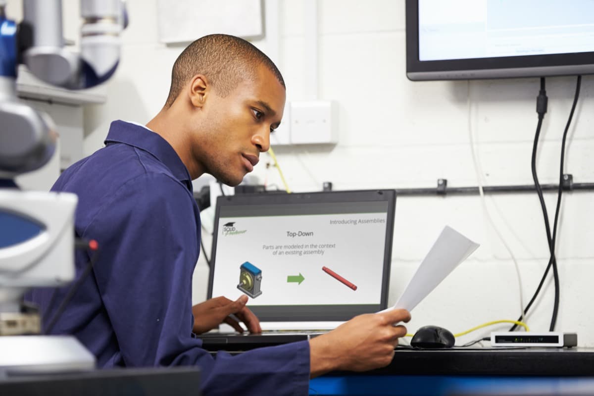 Technician following a SolidProfessor lesson at a workstation.